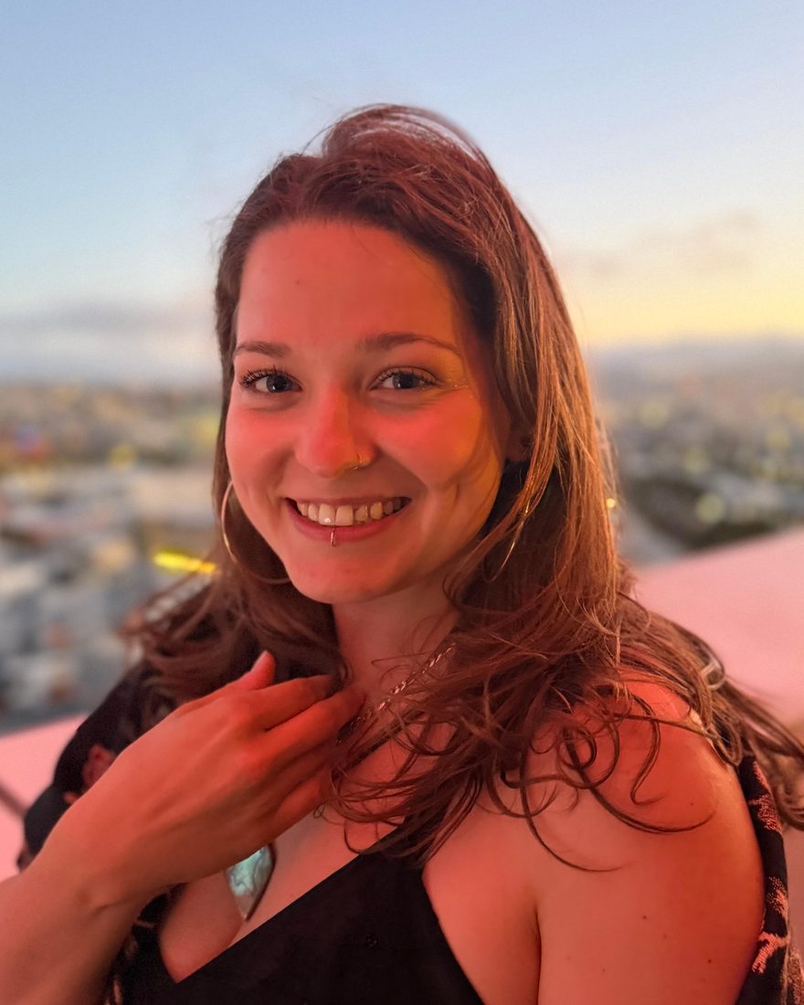 Kaycee, founder of Ruby, smiling on a San Francisco rooftop at sunset
